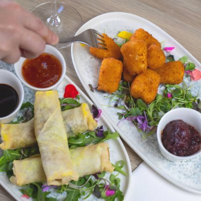 Spring Rolls Loaded with vegetables and served with sticky soy sauce and sweet chilli dipping sauces and Crumbed Camembert Lightly coated camembert pieces, fried until golden and served with cranberry dipping sauce